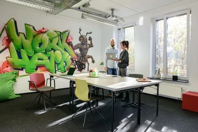 Seminarraum mit zwei sprechenden Personen Rivvers Coworking Space im Dortmunder Technologiepark