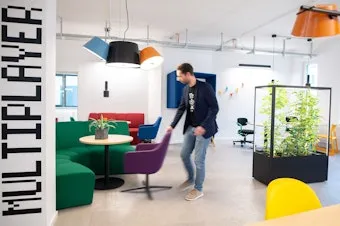 Eine Person verrückt einen Stuhl im Loungebereich im Coworking-Bereich im Coworking Space Rivvers in Mülheim Innenstadt